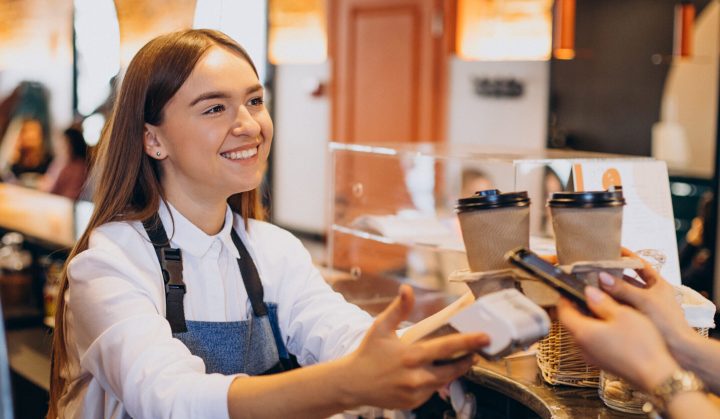 Customer buying coffee at a coffee shop and paying with card
