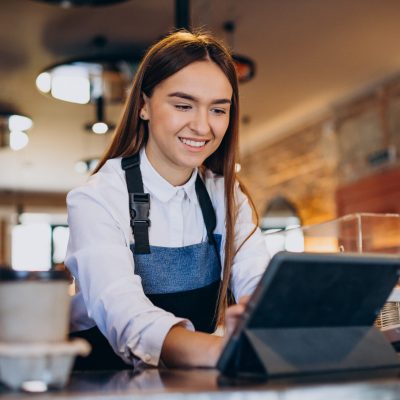 Female barista with tablet making order in a coffee shop